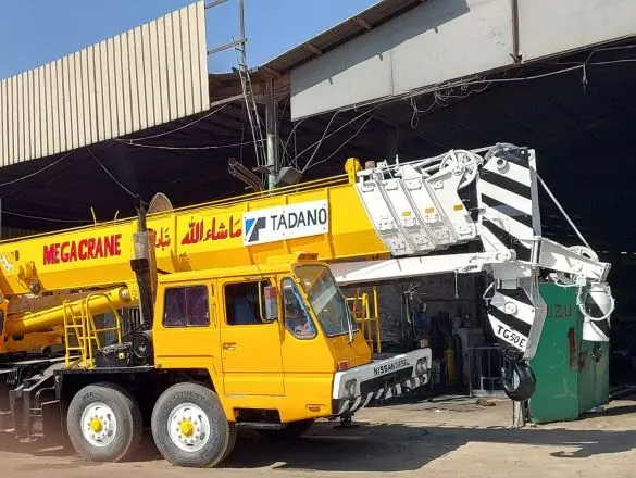 كرين أصفر على شاحنة متعددة المحاور في ساحة المعدات